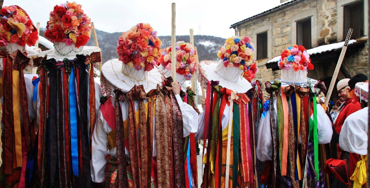 hombres vestidos con ropas de colores y sombreros adornados con flores y bisuterï¿½a