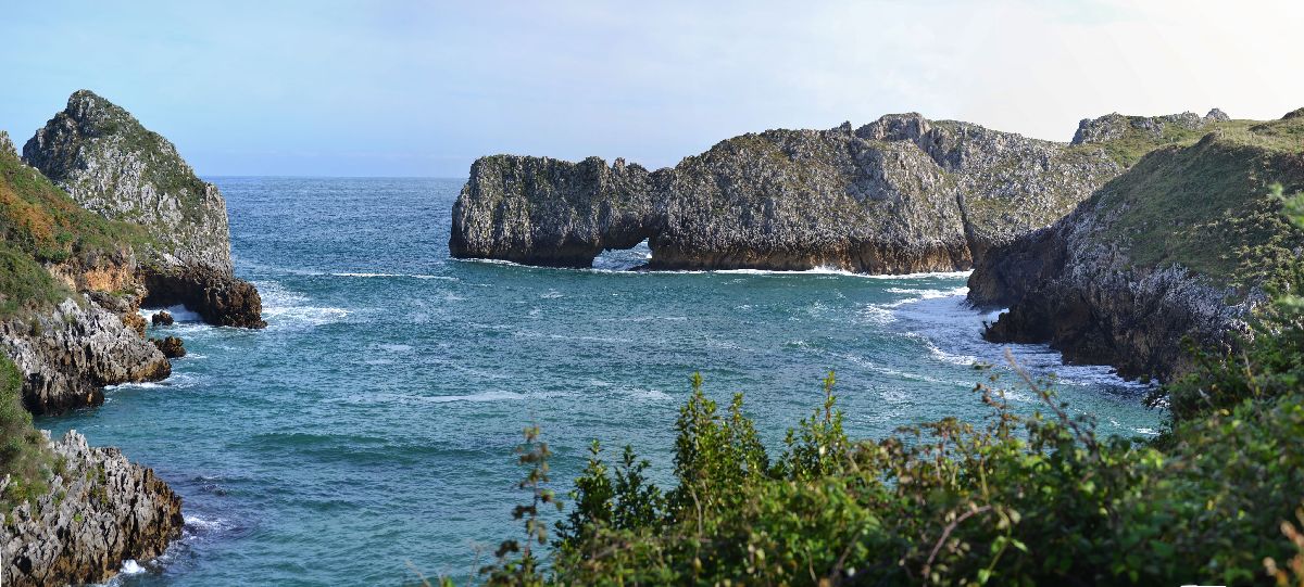 Vista del mar Cantï¿½brico, en dï¿½a soleado, donde se ve un arco de piedra que se ha formado de manera naural