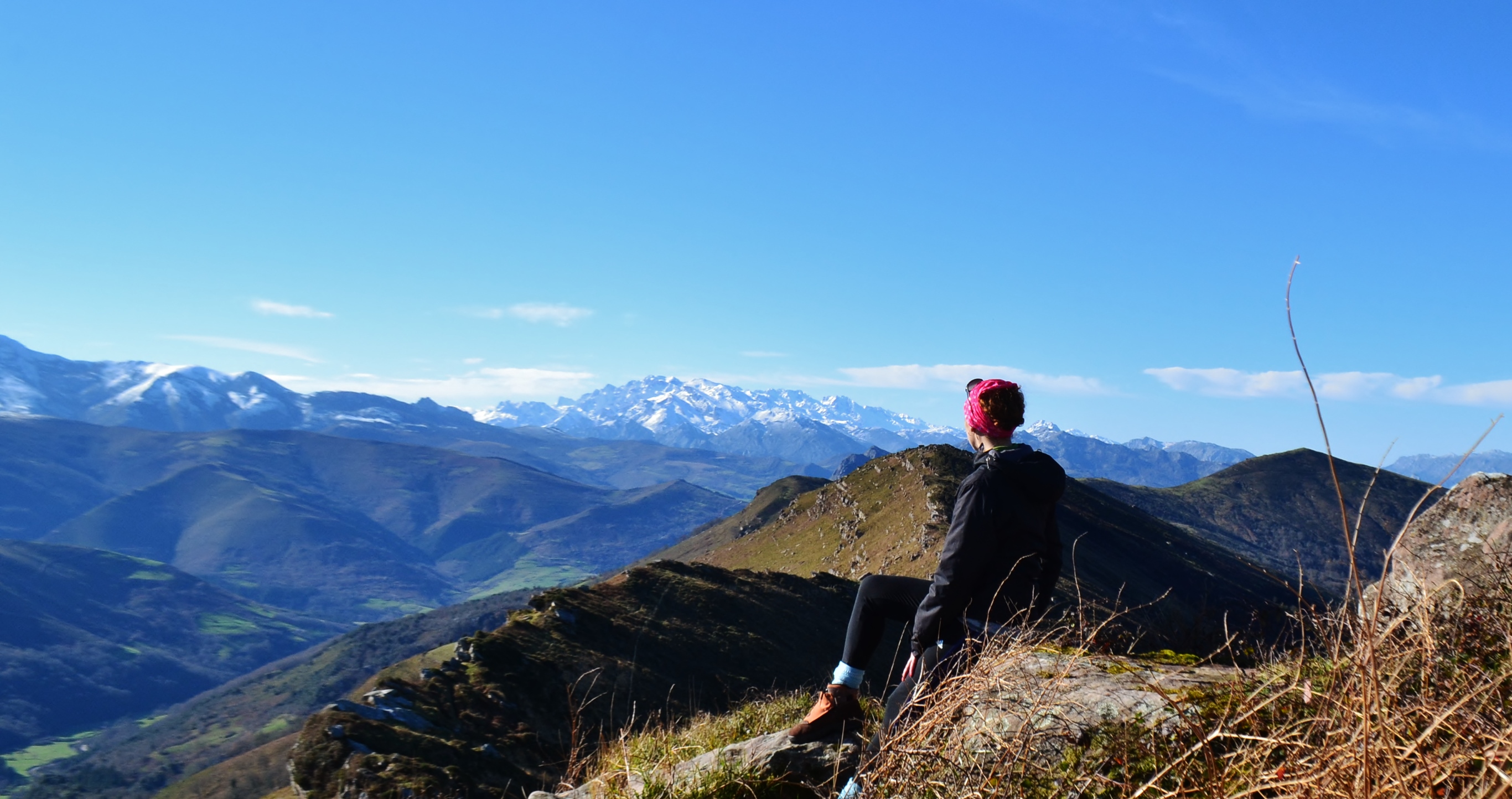 Mujer en la cumbre de la Sierra del Escudo de Cabuï¿½rniga. La vista es la Sierra de peï¿½a Sagra y los Picos de Europa nevados